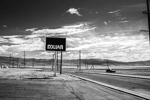 A rural billboard is shown with light traffic surrounding it. 